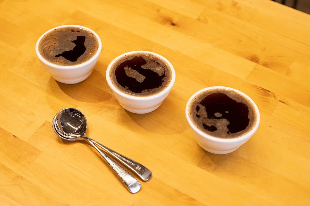 Three cupping bowls with coffee ready to taste.